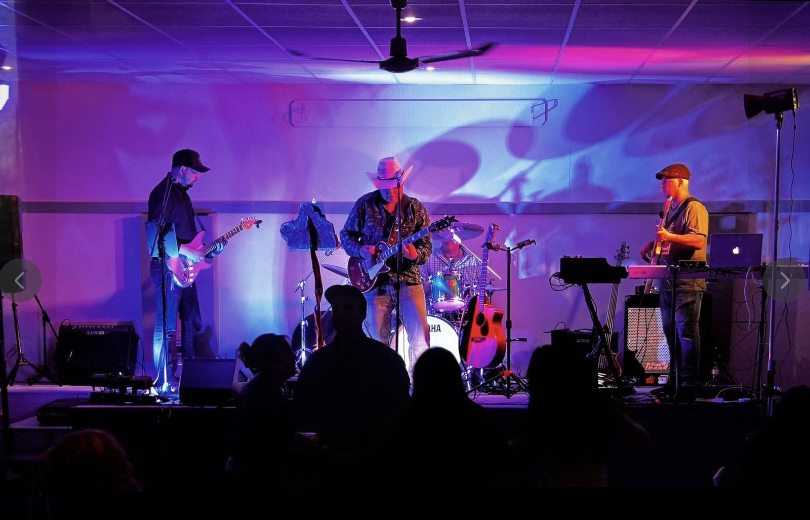 Live band performing at Montney Hall with purple and blue stage lighting